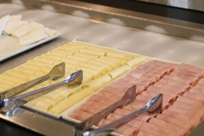 A buffet with neatly arranged food sections. - Samba Belo Horizonte Vintage Apart Hotel (Belo Horizonte)
