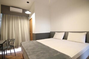 A hotel room with a bed, a desk, and a chair. - Samba Belo Horizonte Vintage Apart Hotel (Belo Horizonte)