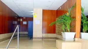 A hotel lobby with a staircase, wooden walls, and potted plants. - Rentalmar Arquus (Salou)