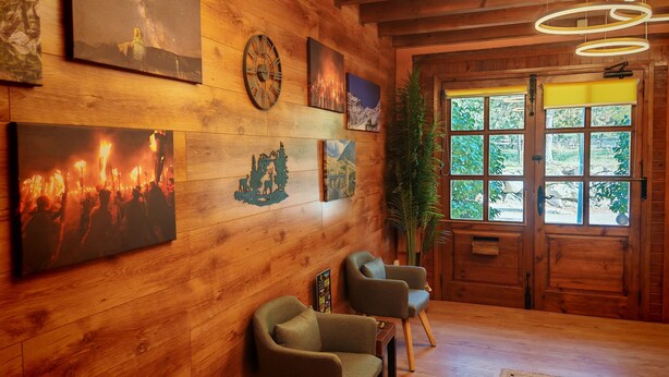 A wooden interior with artwork, a clock, and a door with windows. - Apartaments Pleta Bona (La Vall de Boi)