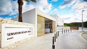 A modern building with a sign reading "SENSATORI RESORT IBIZA". - Insotel Tarida Beach Resort & SPA (Sant Josep de sa Talaia)
