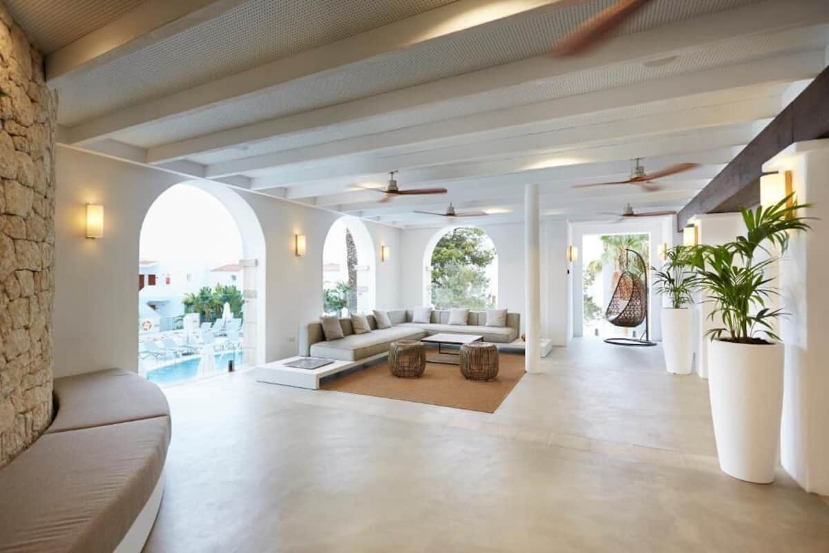 A spacious living area with a large sofa, a coffee table, and a view of the pool.