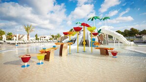 A water park with slides, palm trees, and sun loungers. - Insotel Tarida Beach Resort & SPA (Sant Josep de sa Talaia)