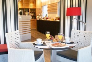 A breakfast setup with a table, chairs, and a kitchen area in the background. - Sitges (Sitges)