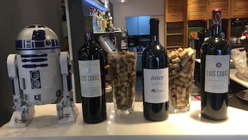 Una zona de bar con botellas de vino, una figurita de R2-D2 y una estantería para vinos.