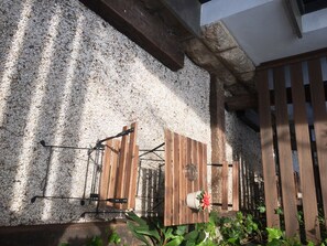 A rustic outdoor area with a wooden fence, a metal gate, and a stone wall. - Sitges (Sitges)