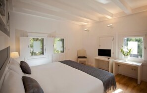 A bedroom with a large bed, a TV, a desk, and two windows. - Sitges (Sitges)