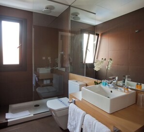 A modern bathroom with a glass shower enclosure, a white sink, and a large mirror. - Sitges (Sitges)