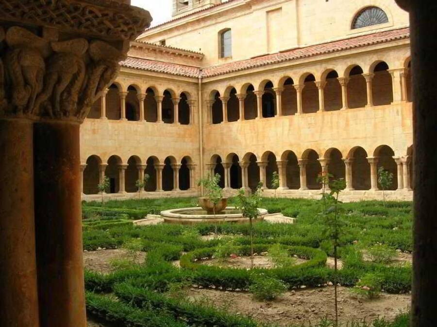 A courtyard with a fountain, surrounded by arches and columns, indicating a historical or cultural site.