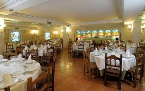 A banquet hall with multiple round tables set for dining, each with white tablecloths and silverware. - Santo Domingo De Silos (Santo Domingo de Silos)