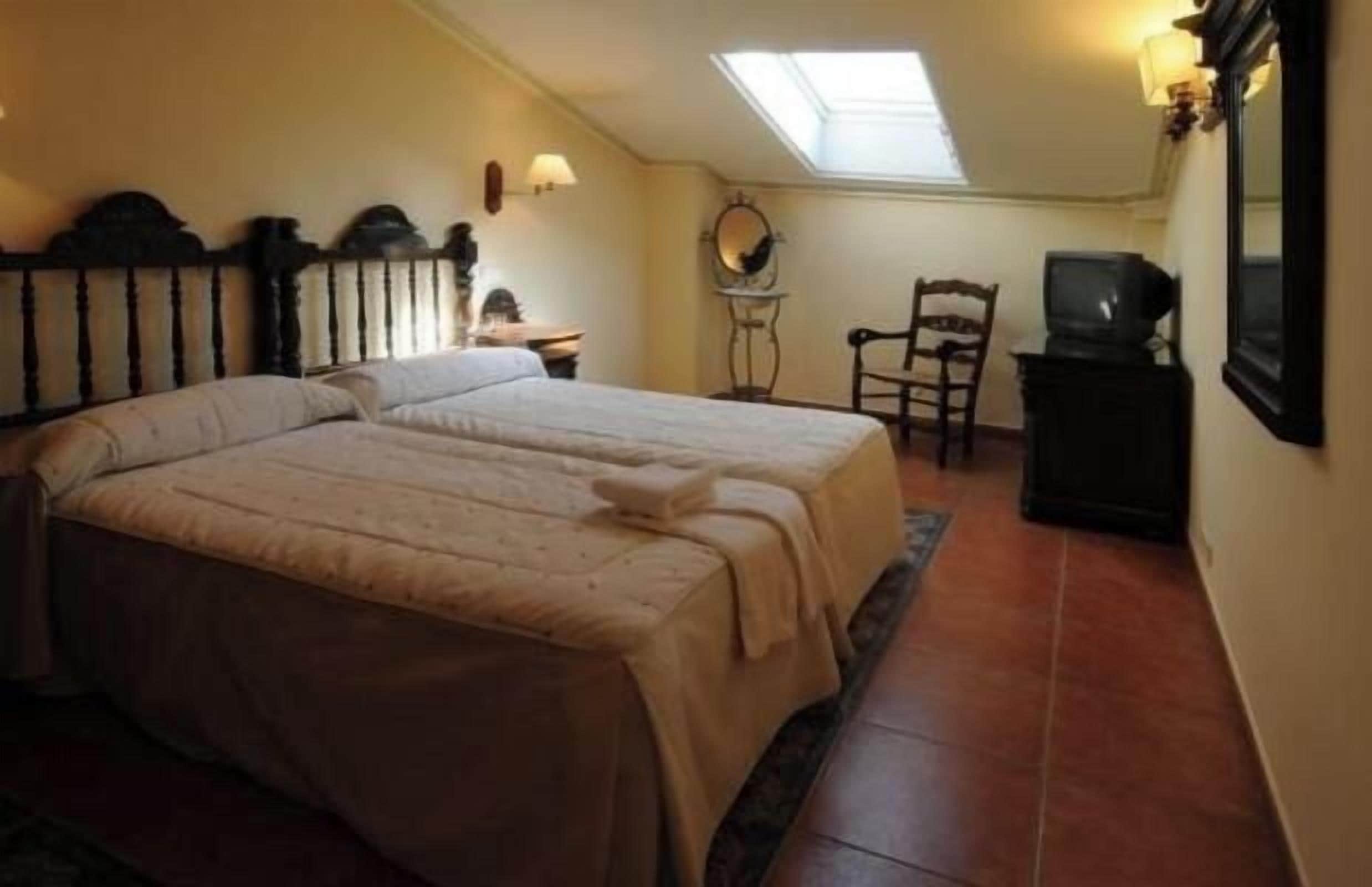Makuuhuoneessa on kaksi sänkyä, työpöytä, tuoli, televisio ja kattovalokuvio.