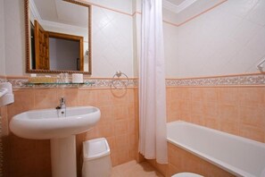 A bathroom with a sink, toilet, bathtub, and a shower curtain. - Santo Domingo De Silos (Santo Domingo de Silos)