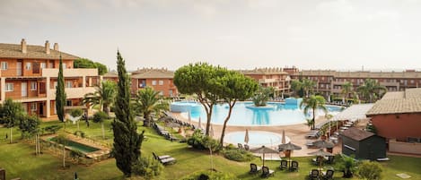 Un resort con múltiples piscinas, áreas de descanso y jardines bien cuidados.