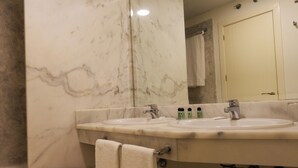 A bathroom with two sinks, a mirror, and a towel rack. - Hotel Vertice Chipiona Mar (Chipiona)