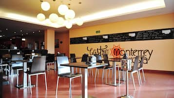 A restaurant with a modern interior, featuring tables and chairs arranged for dining.