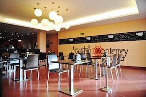 A restaurant with a modern interior, featuring tables and chairs arranged for dining. - Hotel Vertice Chipiona Mar (Chipiona)