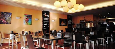 A restaurant with tables and chairs, a menu board, and a ceiling light fixture.