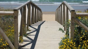 A wooden boardwalk leading to a beach with a clear view of the ocean. - Convento de San Francisco (Vejer de la Frontera)