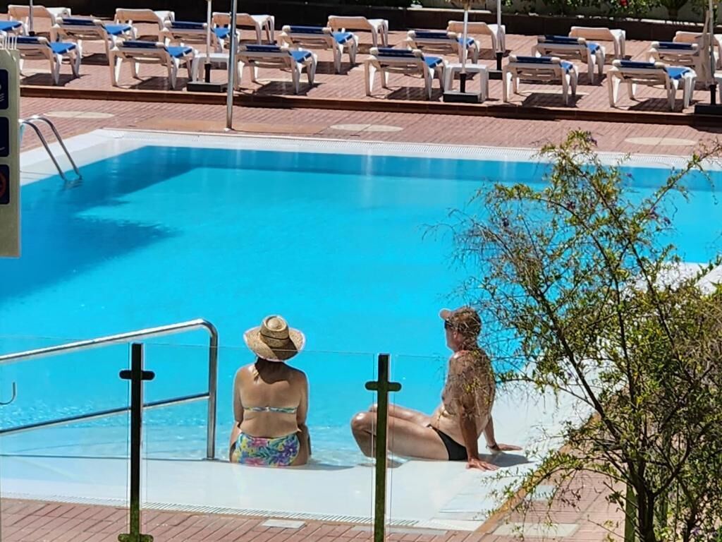 Un área de piscina con sillones de descanso y una piscina.