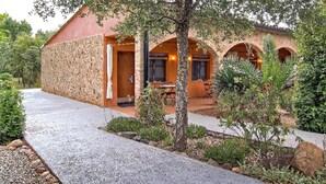A rustic building with a stone facade, wooden door, and arched windows. - Aatu (Forallac)