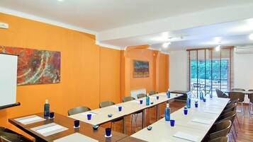 Una sala de conferencias con una mesa larga, sillas y una pizarra.