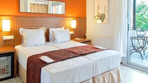Een slaapkamer met een groot bed, houten balken, een plafondlamp, een raam met uitzicht en een kleine tafel met stoel.