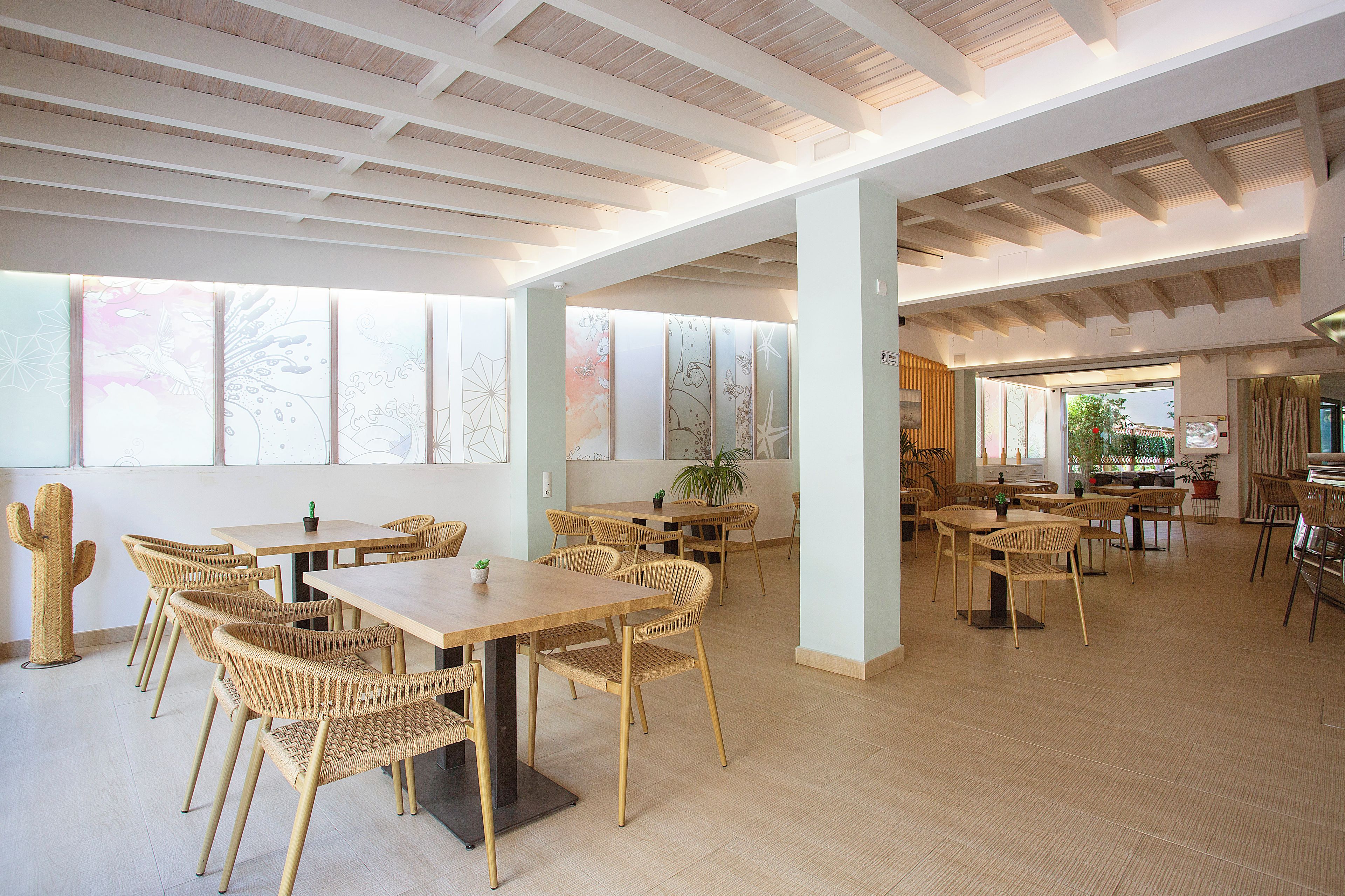 Un comedor espacioso con techos altos, ventanas grandes y luz natural.
