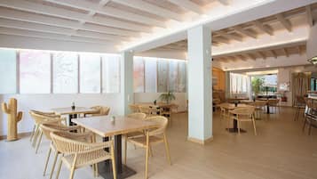 Un comedor espacioso con techos altos, ventanas grandes y luz natural.