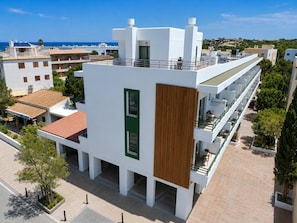 Un edificio moderno con techo plano, paredes exteriores blancas y una puerta verde.