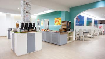 A modern cafe with a central counter, seating area, and artwork on the walls.