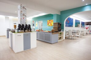 A modern cafe with a central counter, seating area, and artwork on the walls. - Hotel Rosales Formentera (Formentera)