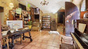 A cozy room with a piano, a dog resting, and a 'Welcome' sign. - Mas Torrencito (Vilademuls)