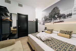 Une chambre d’hôtel avec un lit, un canapé, une armoire et un miroir.