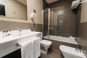 Une salle de bain moderne équipée d’un lavabo, de toilettes et d’une douche.