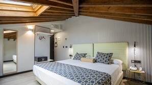 Een slaapkamer met een groot bed, een garderobe, een spiegel en een nachtkastje met een lamp.