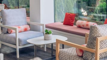 A modern living room with a sofa, armchairs, and a small table.