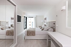 Una habitación de hotel moderna con dos camas, un espejo grande y un escritorio.
