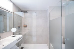 A modern bathroom with a glass shower enclosure, a large mirror, and a white sink. - Petit Sagitario (Ciutadella de Menorca)