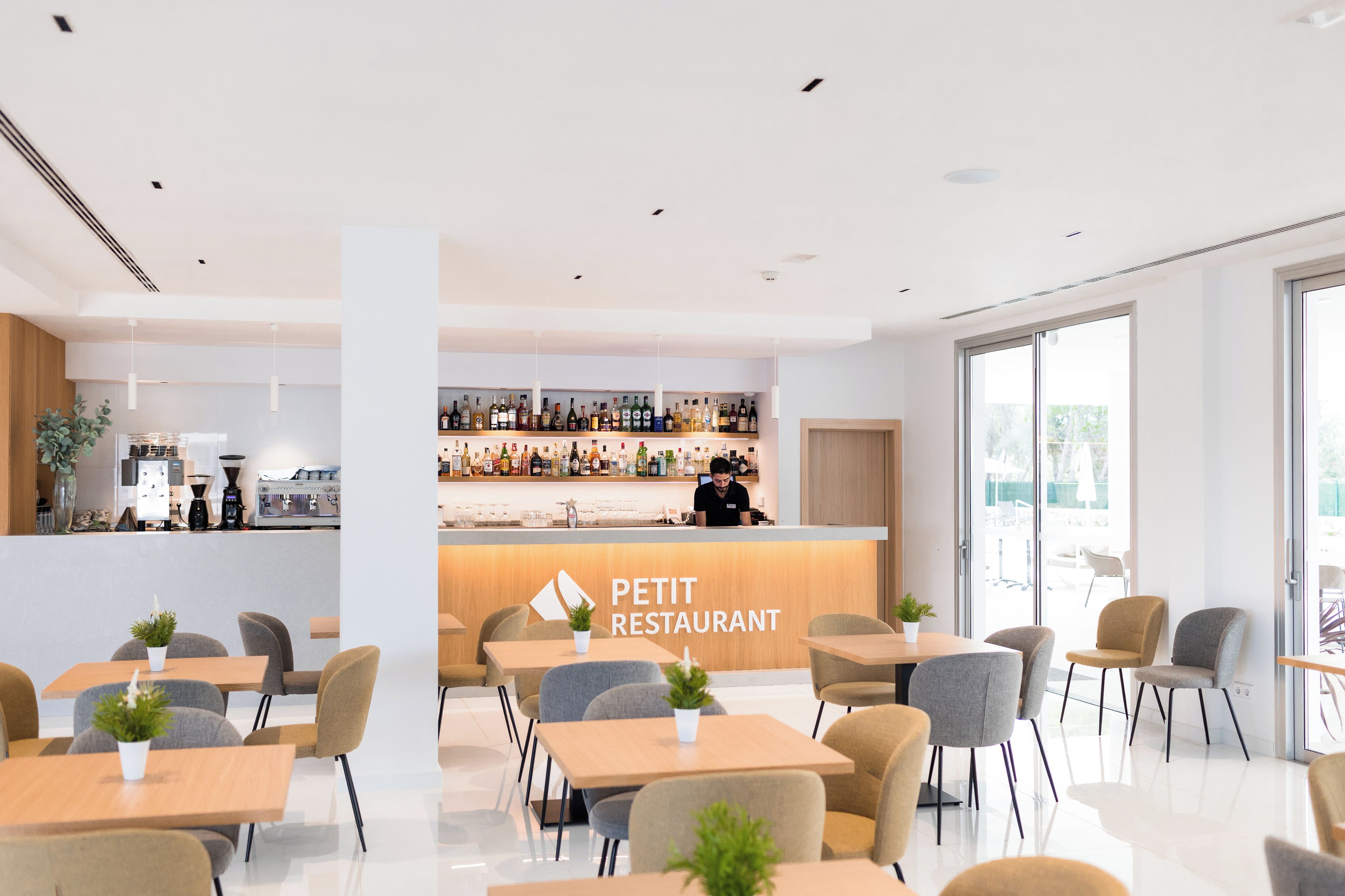 Ein modernes Restaurant mit Bar, Sitzgelegenheiten und einer sichtbaren Speisekarte.
