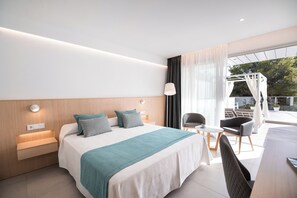 Habitación de hotel moderna con una cama grande, un escritorio pequeño, una silla y vistas al exterior.