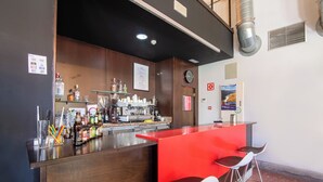 A bar area with a red counter, two bar stools, and a variety of bottles and glasses. - Hotel Rural Aldeaduero (Saucelle)