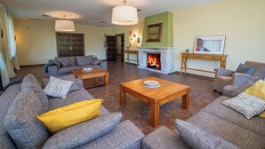 A spacious living room with a fireplace, sofas, and a coffee table. - Hotel Rural Aldeaduero (Saucelle)