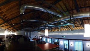 A spacious restaurant with high ceilings and exposed ductwork. Tables and chairs are arranged for dining. - Hotel Rural Aldeaduero (Saucelle)