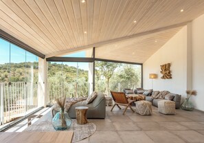 A spacious living area with a large window offering a view of the outdoors, a modern ceiling design, and a comfortable seating arrangement. - Hacienda Fresneda María by Real Spain Hotels (Antequera)