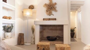 Una sala de estar acogedora con chimenea, detalles de madera y una lámpara de pie.