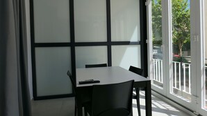 A room with a large window, a table, and chairs. - Rentalmar Aries Plus (Salou)