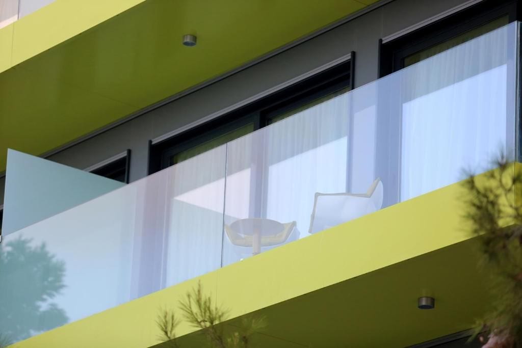 Un edificio moderno con fachada verde y ventanas amplias.