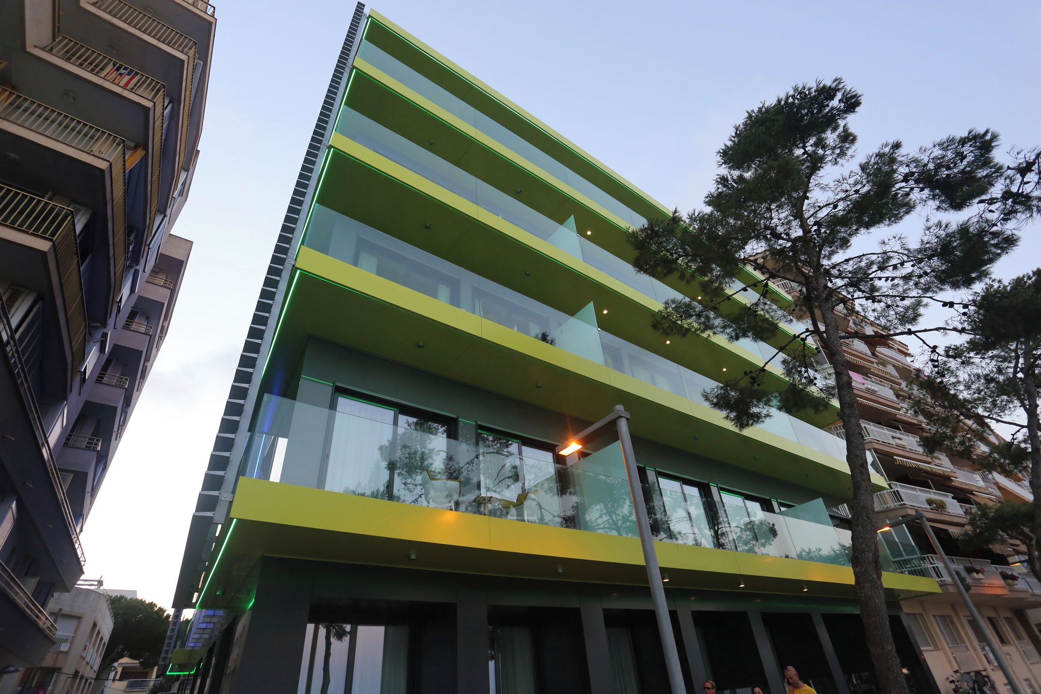 A modern building with multiple floors, large windows, and balconies.