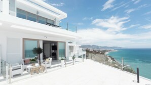 A modern white building with a balcony overlooking a coastal view. - Apartamentos Martalia Nerja (Torrox)