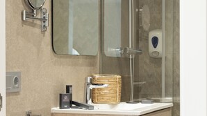 A modern bathroom with a wooden vanity, a glass shower enclosure, a round mirror, and a towel rack. - Apartamentos Martalia Nerja (Torrox)